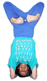 A student in a supported headstand wearing an Iyengar Yoga T-shirt