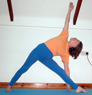 Sallie Sullivan in utthita trikonasana in a hall